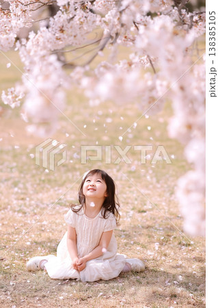 春の公園で、満開の桜と幸せそうに遊ぶ子供 138385105