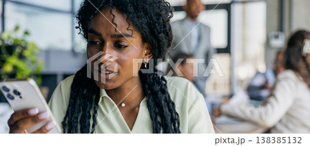 Female professional examines timesensitive message on mobile device 138385132