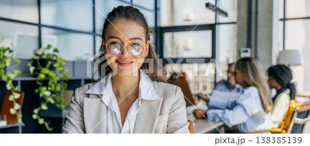 Welcoming female boss surrounded by helpful coworkers smiling brightly 138385139