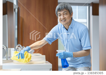 カメラ目線で笑顔のシニアの男性清掃スタッフ 138385305