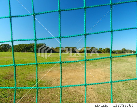 冬の江戸川河川敷のバックネット裏から見る野球場とサッカー場の風景 冬の江戸川河川敷のバックネット裏から見る野球場とサッカー場の風景 138385369