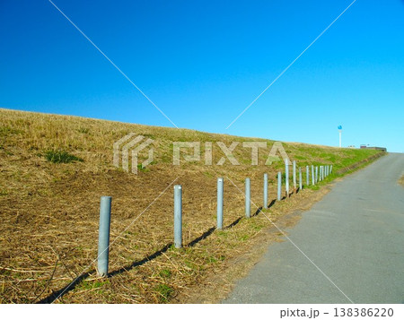 初冬の除草された杭のある江戸川土手と青空風景 138386220