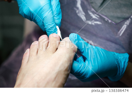 Professional Pedicure Procedure. Nail Technician Using Nail Clippers. Professional nail care service showing precise toenail cutting technique. Nail clippers. Professional Pedicure Procedure. Nail Technician Using Nail Clippers. Professional nail care service showing precise toenail cutting technique. Nail clippers. 138386474