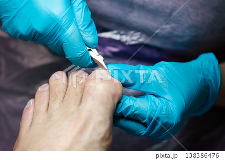 Professional Pedicure Procedure. Nail Technician Using Nail Clippers. Professional nail care service showing precise toenail cutting technique. Nail clippers. 138386476