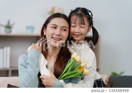 Mother's Day celebration with daughter giving flowers and card Mother's Day celebration with daughter giving flowers and card 138386499