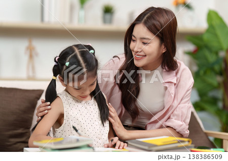 Mother guiding daughter through homework 138386509