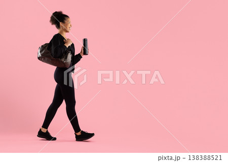 Young athletic black woman walking with gym bag and water bottle Young athletic black woman walking with gym bag and water bottle 138388521