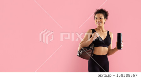 Closeup of sporty black woman holding water bottle and gym bag Closeup of sporty black woman holding water bottle and gym bag 138388567