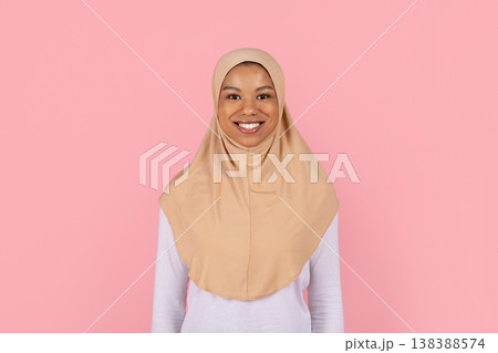 Young black Muslim woman in beige hijab smiling confidently at camera Young black Muslim woman in beige hijab smiling confidently at camera 138388574