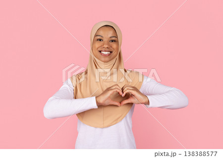 Young black Muslim woman in hijab forming heart shape with hands Young black Muslim woman in hijab forming heart shape with hands 138388577