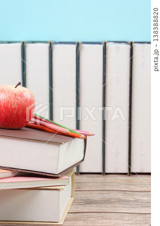 Stack of books with apple and pencils 138388820