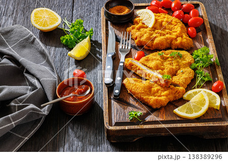 Crispy meat schnitzel served on wooden cutting board 138389296