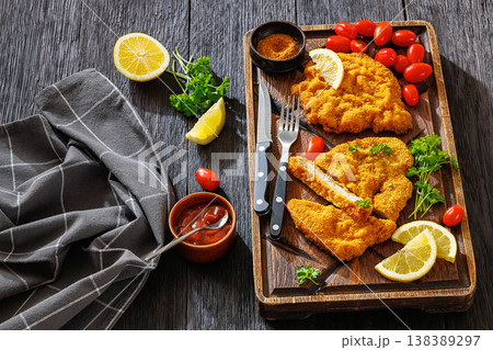 Crispy meat schnitzel served on wooden cutting board Crispy meat schnitzel served on wooden cutting board 138389297