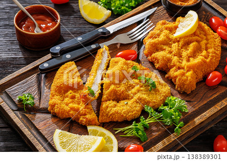 Crispy meat schnitzel served on wooden cutting board Crispy meat schnitzel served on wooden cutting board 138389301