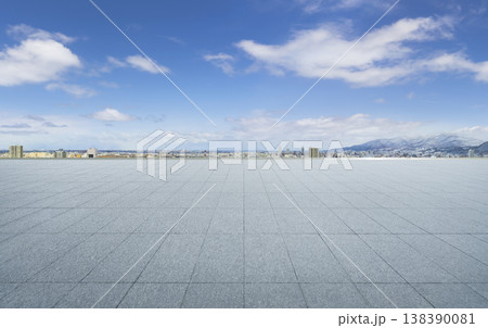 Empty tiled plaza with city skyline and snowy mountains Empty tiled plaza with city skyline and snowy mountains 138390081