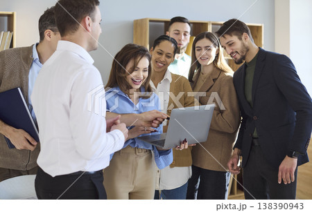 Happy team of colleagues around laptop discussing ideas in a bright office Happy team of colleagues around laptop discussing ideas in a bright office 138390943