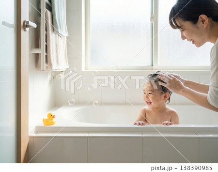 やわらかな光の中で愛情深く赤ちゃんをお風呂に入れる母と子 138390985