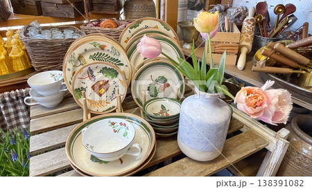Beautiful hand painted ceramic plates and fresh pink tulips in a rustic gift shop display interior Beautiful hand painted ceramic plates and fresh pink tulips in a rustic gift shop display interior 138391082