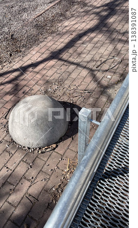 Concrete hemisphere bollard on brick pavement for traffic control and safety in modern urban space Concrete hemisphere bollard on brick pavement for traffic control and safety in modern urban space 138391087