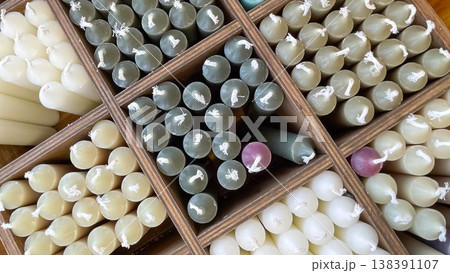 Top view of assorted colorful wax taper candles organized in a wooden divider box in a decor shop Top view of assorted colorful wax taper candles organized in a wooden divider box in a decor shop 138391107