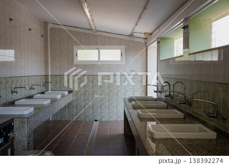 Public restroom interior with multiple sinks and mirrors clean tiled bathroom facility hygiene sanitation concept Public restroom interior with multiple sinks and mirrors clean tiled bathroom facility hygiene sanitation concept 138392274