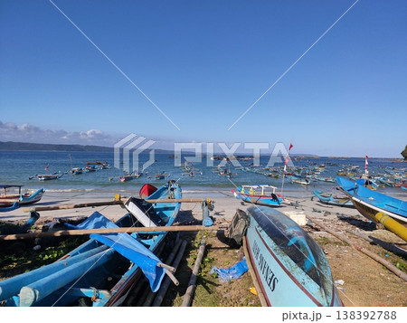 Colorful fishing boats rest under a bright blue sky on a peaceful tropical beach. Colorful fishing boats rest under a bright blue sky on a peaceful tropical beach. 138392788