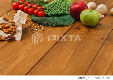Fresh vegetables, fruits and nuts on rustic wood background with copy space. Healthy natural food on table. Vegetarian cooking ingredients Fresh vegetables, fruits and nuts on rustic wood background with copy space. Healthy natural food on table. Vegetarian cooking ingredients 138393260