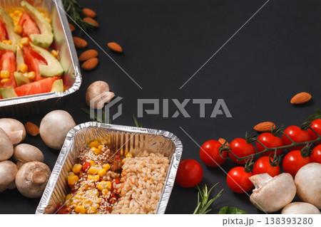 Healthy restaurant food delivery dark background with copy space. Mockup for menu, foil containers with meals on black 138393280