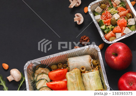 Healthy restaurant food delivery dark background with copy space. Mockup for menu, foil containers with meals on black Healthy restaurant food delivery dark background with copy space. Mockup for menu, foil containers with meals on black 138393375