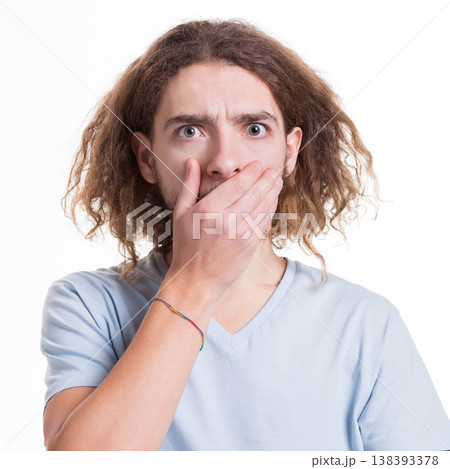 Keep silence. Gossip concept. Surprised man covering mouth with hand on white isolated studio background 138393378