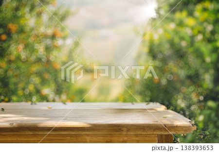 Wooden Table with Orange Orchard Background in Natural Sunlight 138393653