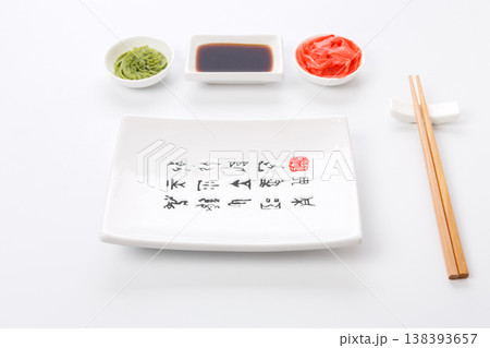 Set of sushi tablewear. Empty rectangular sushi plate with hieroglyphs, saucer, ginger, wasabi and chopsticks at white background. Flat lay, copy space Set of sushi tablewear. Empty rectangular sushi plate with hieroglyphs, saucer, ginger, wasabi and chopsticks at white background. Flat lay, copy space 138393657