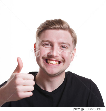I like it. Happy man showing thumb up gesture and smiling on white isolated background, studio shot 138393918