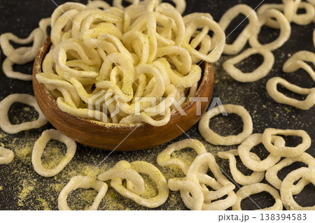 crispy onion rings made from onion puree and flour fried in a large amount of sunflower oil , delicious high-calorie onion rings made from natural ingredients, poured in a wooden bowl crispy onion rings made from onion puree and flour fried in a large amount of sunflower oil , delicious high-calorie onion rings made from natural ingredients, poured in a wooden bowl 138394583