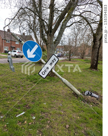 One way sign that a car has driven into a broken knocked over damaged traffic pole 138394883
