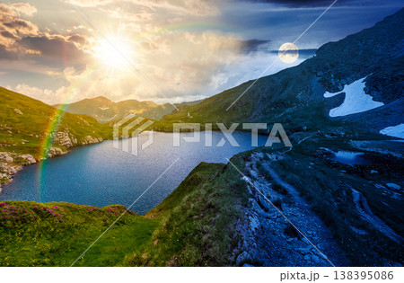 gorgeous summer solstice on capra lake. day meet night. sun and moon over breathtaking view of transylvaia alps in romania. composite background image for astrology wallpaper concept 138395086