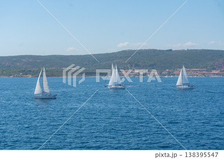 Several sailboats sailing together on open sea. Sailing sport, teamwork and summer activity concept 138395547