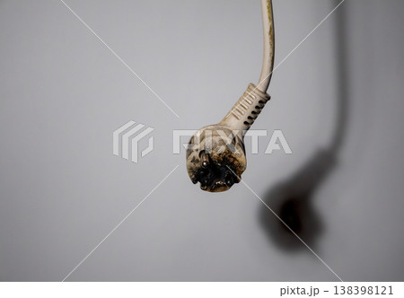Damaged Electric rubber plug with cord on white background. Short circuit electrical circuit. Broken electrical connection. Damaged Electric rubber plug with cord on white background. Short circuit electrical circuit. Broken electrical connection. 138398121