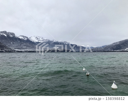 views from the shore of lake annecy after the last snowfall 138398812