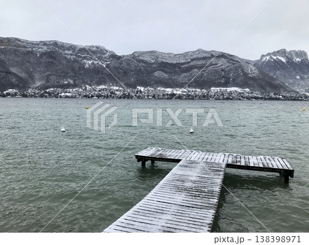 views from the shore of lake annecy after the last snowfall 138398971