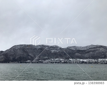 views from the shore of lake annecy after the last snowfall 138398983