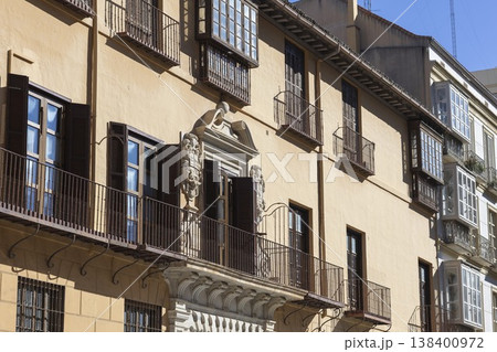 Historic architecture in sunny Malaga, Spain showcasing elegant balconies and intricate stonework Historic architecture in sunny Malaga, Spain showcasing elegant balconies and intricate stonework 138400972