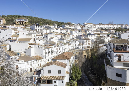 View of Setenil de las Bodegas with white houses and river in sunny weather View of Setenil de las Bodegas with white houses and river in sunny weather 138401023