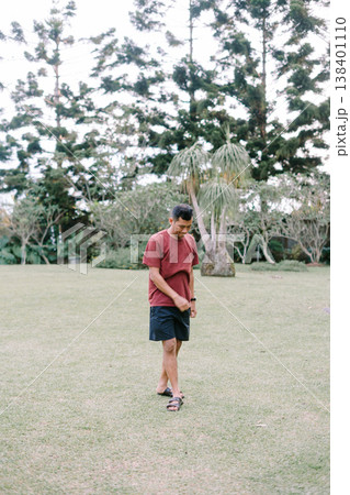 Man scanning horizon in open green field landscape 138401110