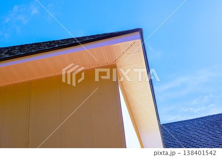 House corner is under installing fiber siding with roof structure highlighting building work design. House corner is under installing fiber siding with roof structure highlighting building work design. 138401542
