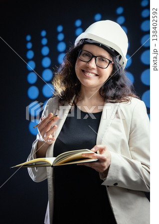 Woman engineer smiling, holding notebook planning new project Woman engineer smiling, holding notebook planning new project 138402592