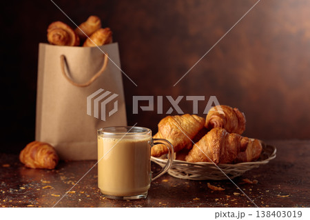Coffee latte and croissants on a brown table. Coffee latte and croissants on a brown table. 138403019
