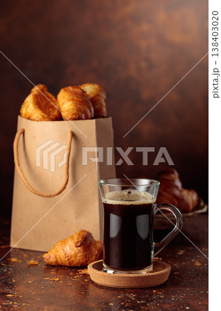Black coffee and paper bag with croissants. Black coffee and paper bag with croissants. 138403020