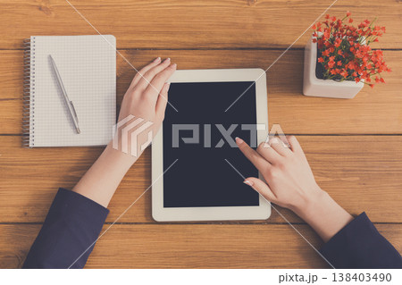 Top view businesswoman touch screen of tablet in office. Freelancer working with portable computer with copy space on display Top view businesswoman touch screen of tablet in office. Freelancer working with portable computer with copy space on display 138403490