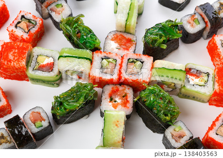 Japanese food restaurant delivery. Sushi platter of colorful rolls and gunkans with seaweed. Big party set at white, pov, sushi assortment background Japanese food restaurant delivery. Sushi platter of colorful rolls and gunkans with seaweed. Big party set at white, pov, sushi assortment background 138403563